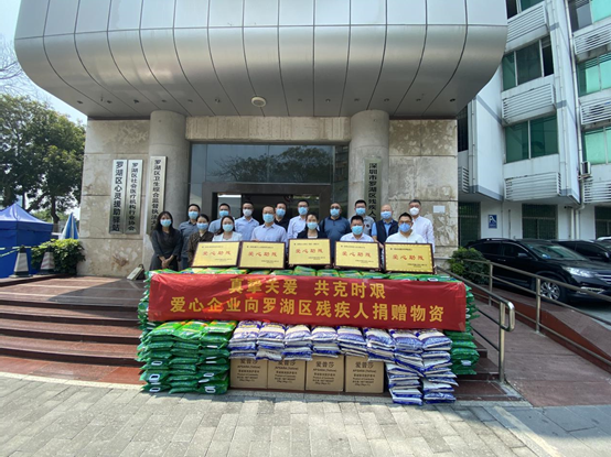 罗湖区pg电子班子成员和各科室负责人、5家企业代表与部分爱心物资合影.png